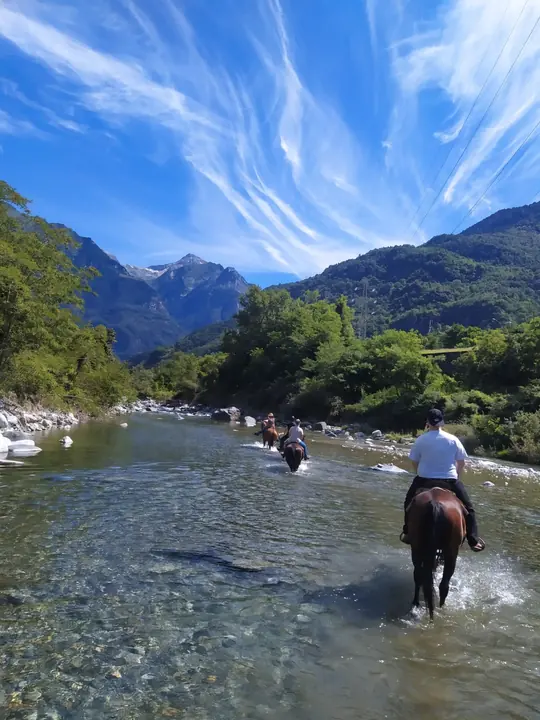 Cavalieri nel fiume sotto un cielo di nuvole